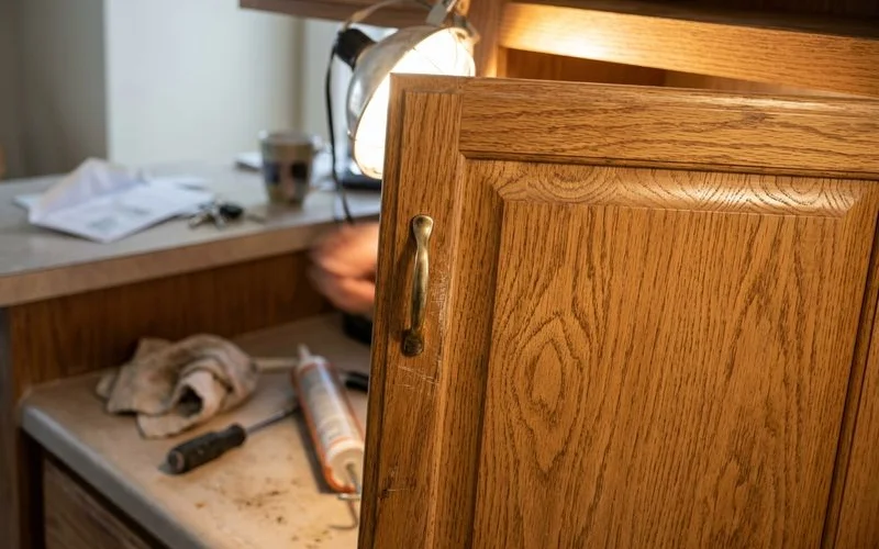 Close-up of oak grain texture on a cabinet door under a work light