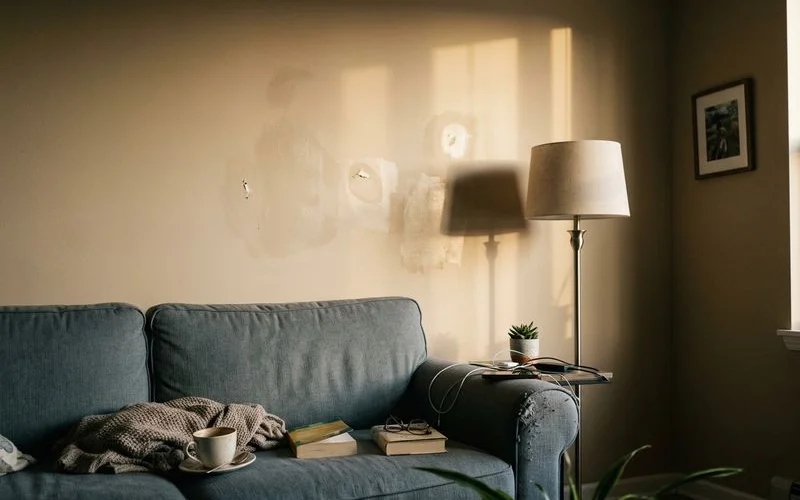 Patchy touch-up marks visible on a living room wall in raking light