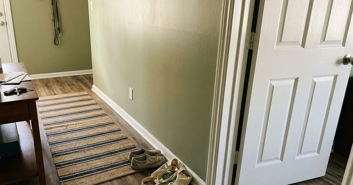 Satin wall catching window light beside glossy white trim and a door