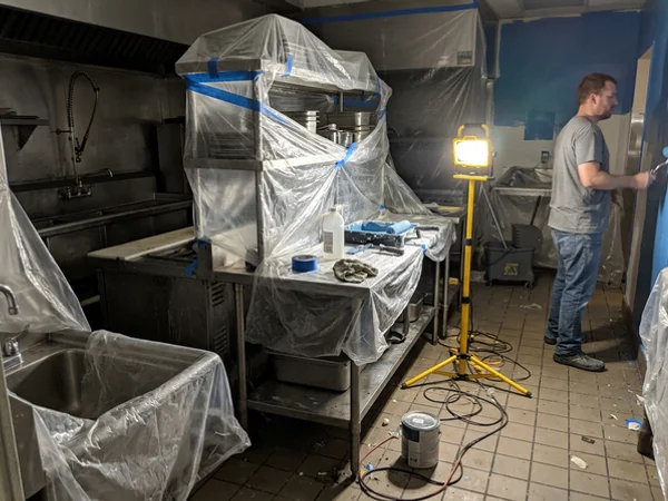 Restaurant prep area with equipment covered during painting