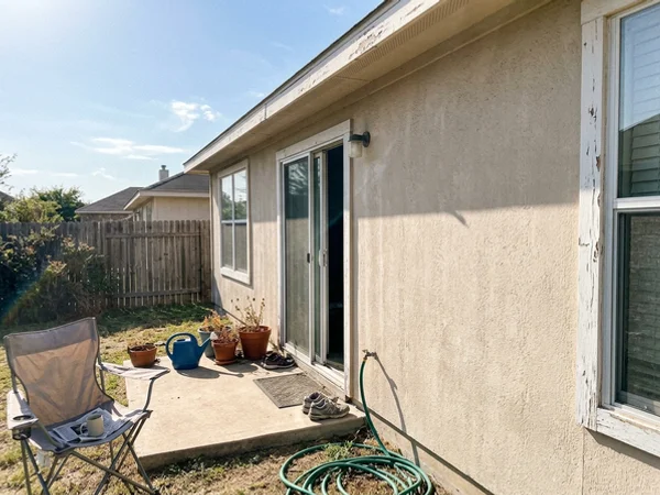 Before: faded, chalky west wall and peeling trim on a 1990s Central Texas home