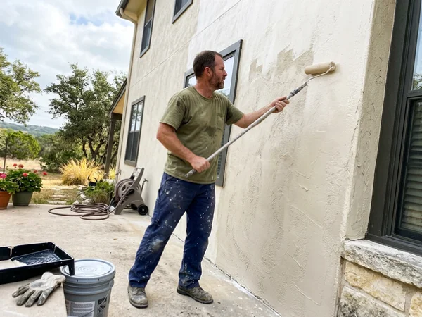 Rolling elastomeric coating on a Hill Country stucco wall
