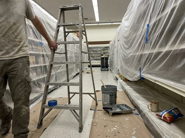 Retail shelves wrapped in plastic for overnight painting