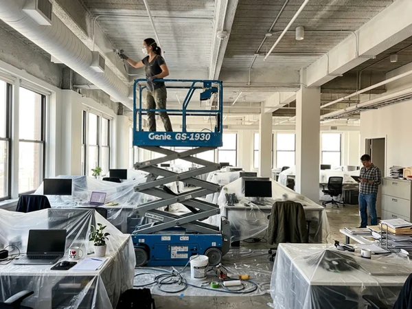Scissor lift in an open-plan office for ceiling painting